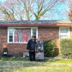 The Wilson's in front of their Portsmouth, ranch-style home